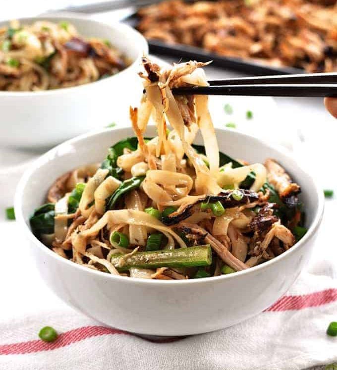 Chopsticks picking up Crispy Shredded Chicken Noodle Stir Fry from a bowl.