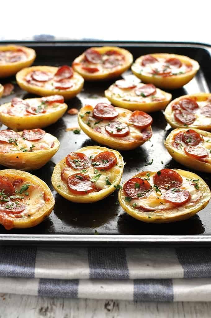 Mini Pizza Potato Skins on a black tray, fresh out of the oven.