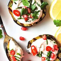 Grilled Eggplant discs topped with yoghurt sauce, pomegranate and coriander