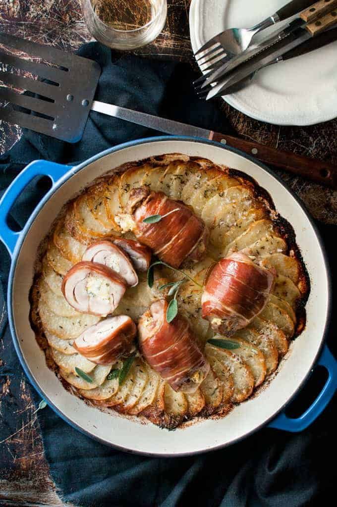 Prosciutto Wrapped Chicken and Scalloped Potatoes in a round blue casserole pan