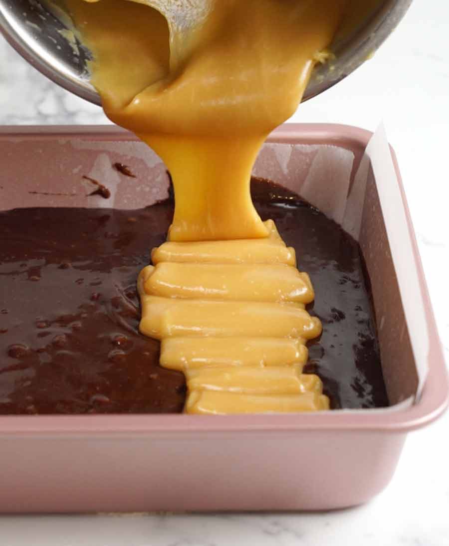 Pouring caramel over brownies