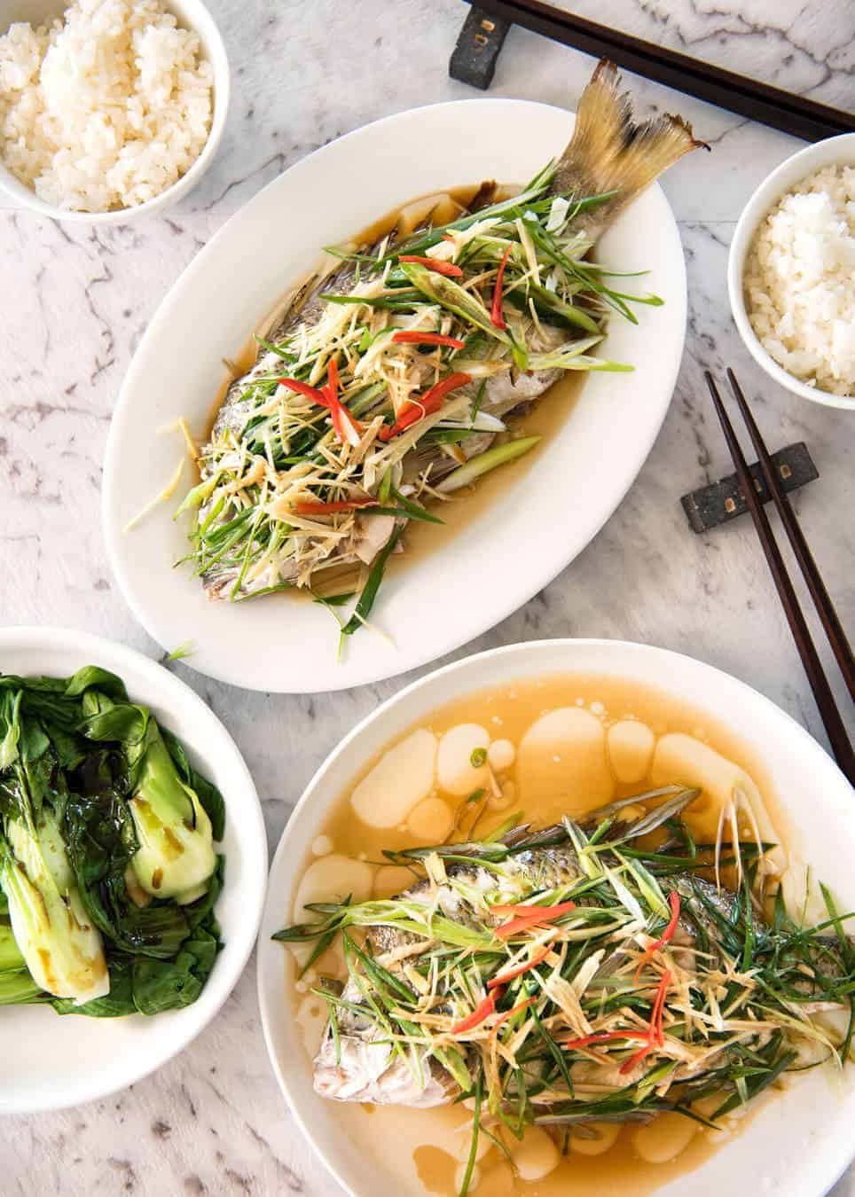 A Chinese Steamed Fish topped with Ginger and Shallots and seasonings, with hot oil poured over it to create a dramatic sizzle and an amazing sauce. So simple, yet so utterly delicious. Steam OR bake the fish! www.recipetineats.com