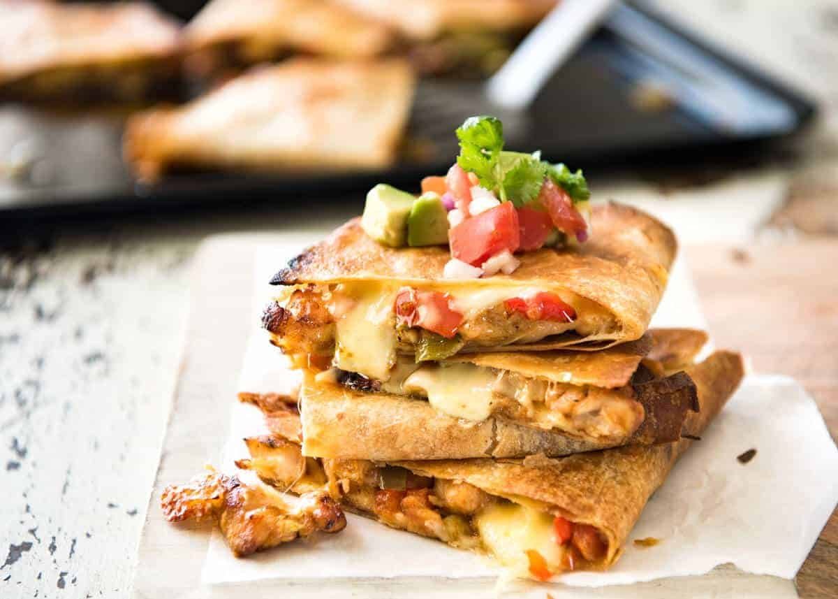 Crispy Oven Baked Chicken Quesadillas - This is how to make multiple Quesadillas at the same time! Crispy on the outside, stuffed with Mexican seasoned chicken and capsicum / bell peppers (and cheese of course!) www.recipetineats.com