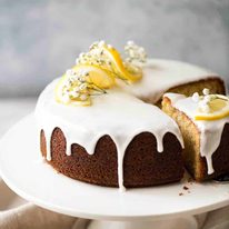 Lemon Yoghurt Cake with Drippy Lemon Glaze on a cake stand