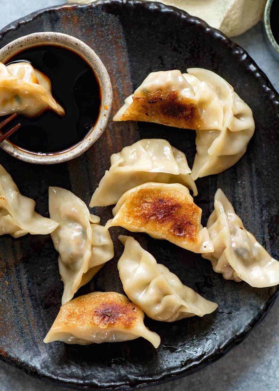 Potstickers / Pan Fried Chinese Dumplings on a dark brown plate shot from overhead
