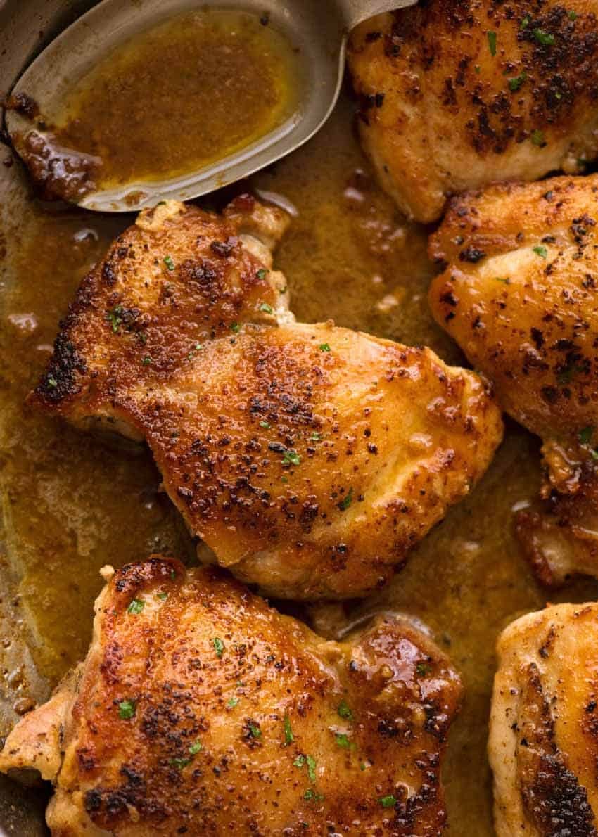 Close up of Crispy Garlic Chicken Thighs in a skillet with garlic butter sauce, ready to be served