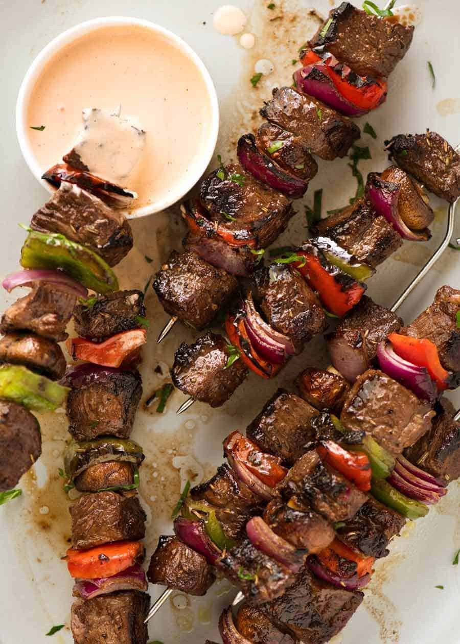 Overhead photo of Marinated Beef Kabobs with a pink sauce