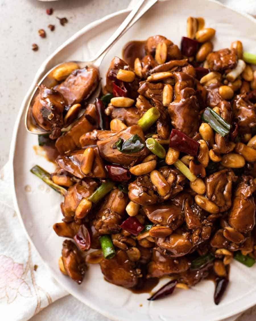 Overhead photo of Kung Pao Chicken on a rustic white plate, ready to be served