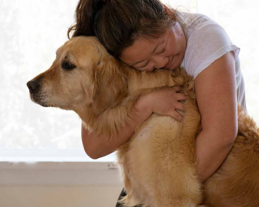 Nagi from RecipeTin Eats hugging Dozer the golden retriever dog