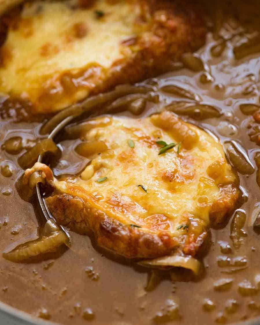 Close up of French Onion Soup being ladled out of pot