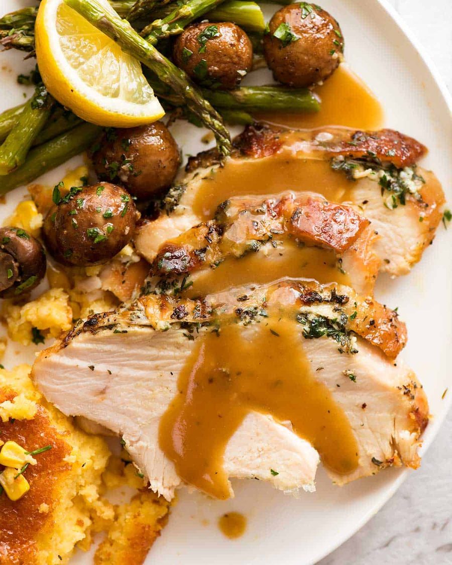Slow Cooker Garlic Herb Turkey Breast dinner plate with creamy corn casserole, roasted mushrooms, and lemon garlic asparagus