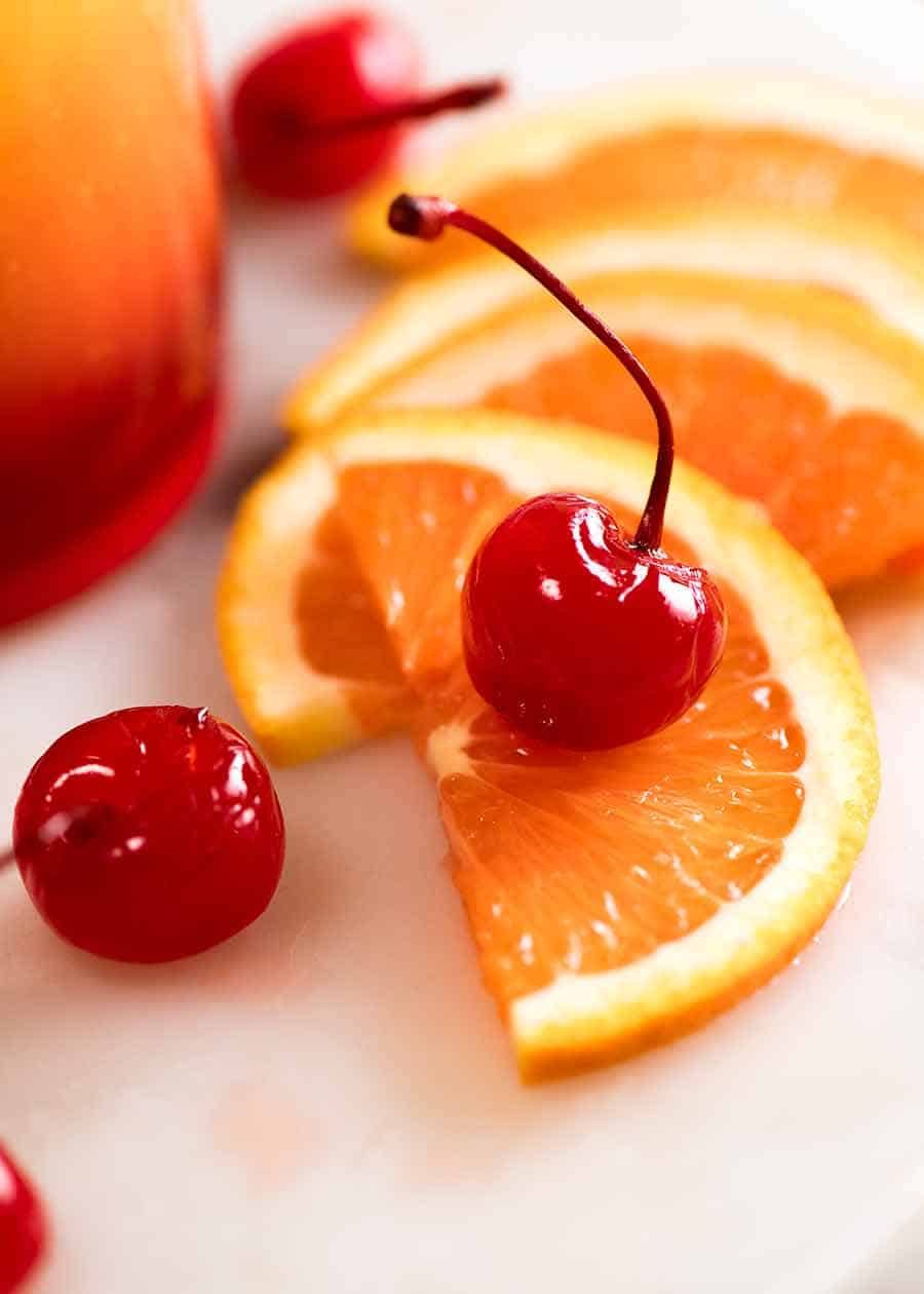 Photo of orange slices and Maraschino cherries, garnish for Tequila Sunrise cocktail