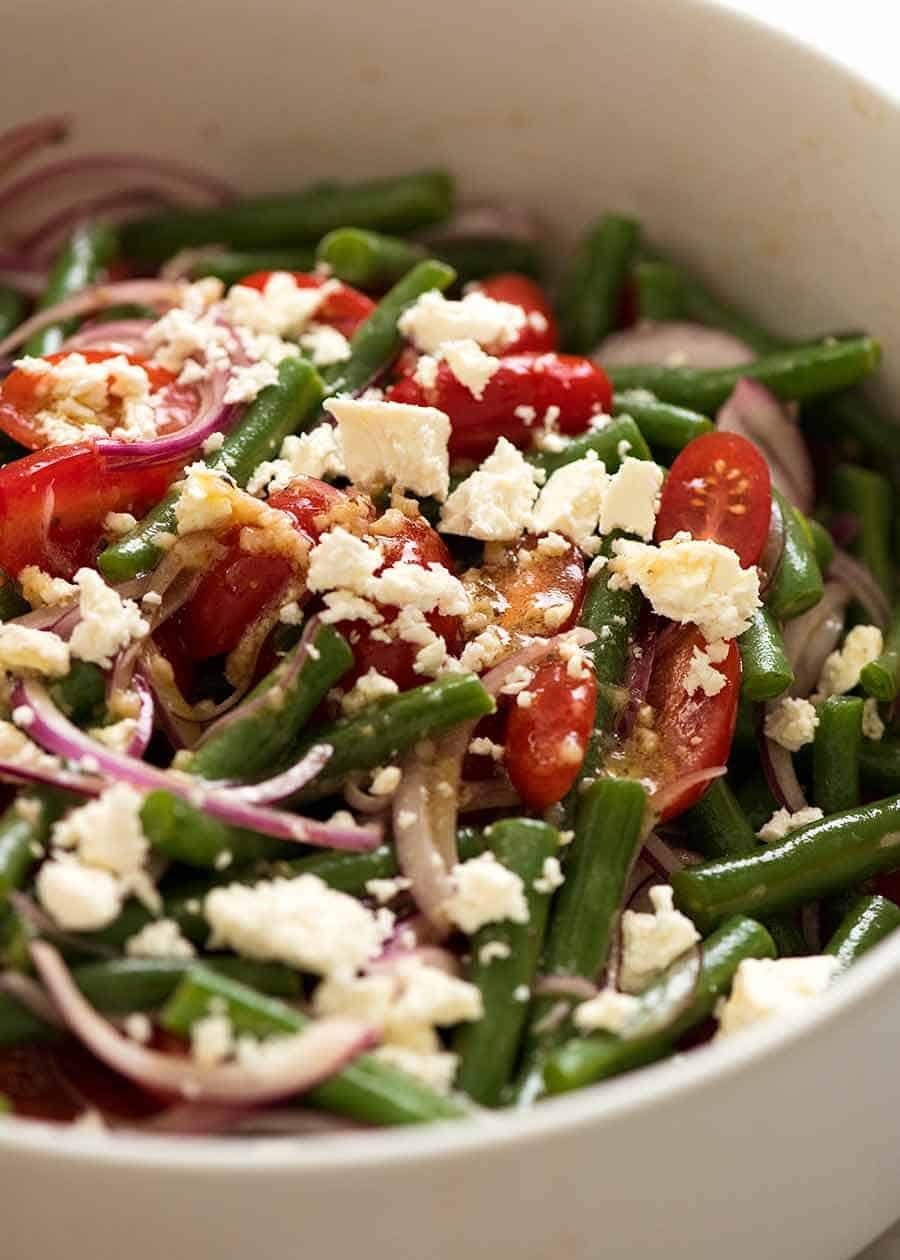 Close up of Green Bean Salad with Cherry Tomatoes and Feta in a white salad bowl, ready to be served