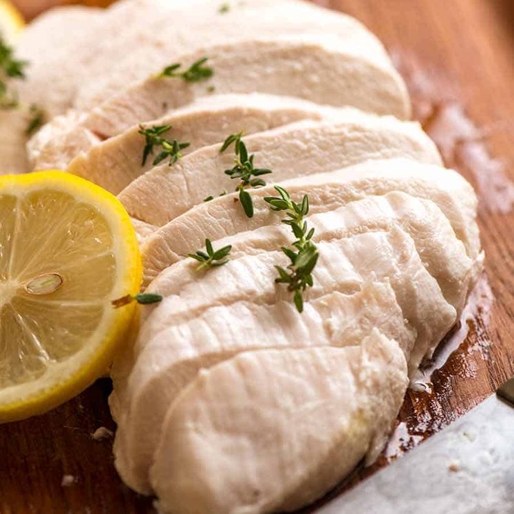 Sliced Poached Chicken breast on a cutting board