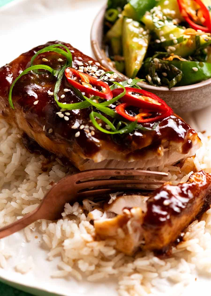 Close up of Asian Glazed Baked Barramundi on coconut rice with a side of cucumber salad