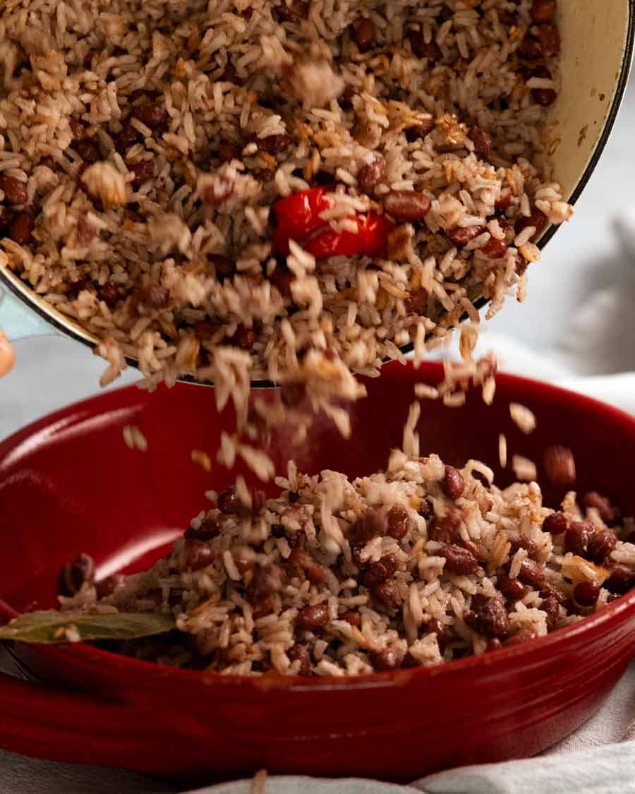 Pouring cooked Jamaican Coconut Rice and Peas (Beans) in a bowl